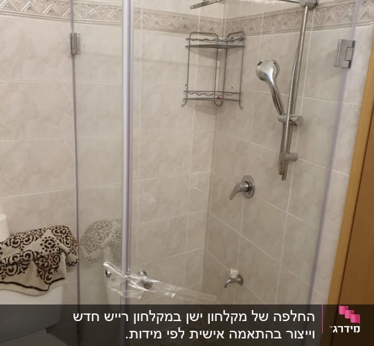 מקלחת עם דלת זכוכית, ראש מקלחת ומדף מתכת